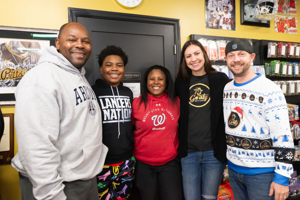 A family looking for baseball cards, posing with the owners